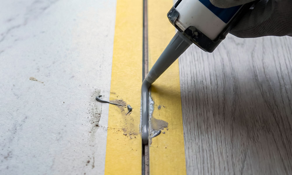 Нанесение полиуретанового герметика в стык пола